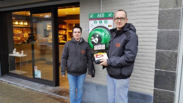 Bakker hangt en bekostigt zelf AED toestel - bakker en echtgenote met AED