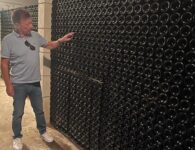 Patrick Vandewattyne bij de wijnflessen