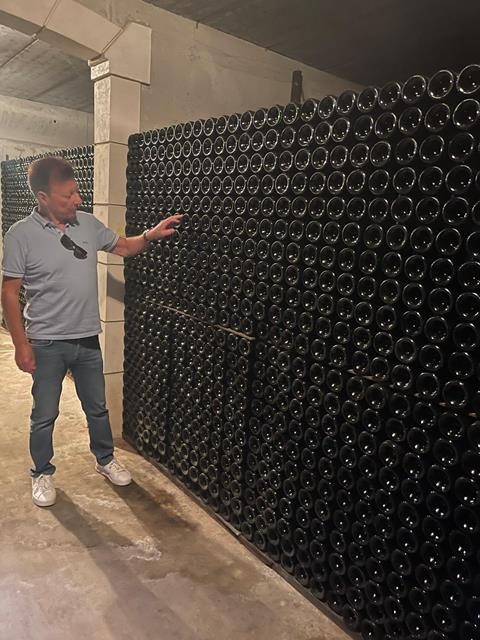 Patrick Vandewattyne bij de wijnflessen