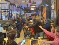 Koopzondag Leuven Johnny Trash met rode guitaar in cafe